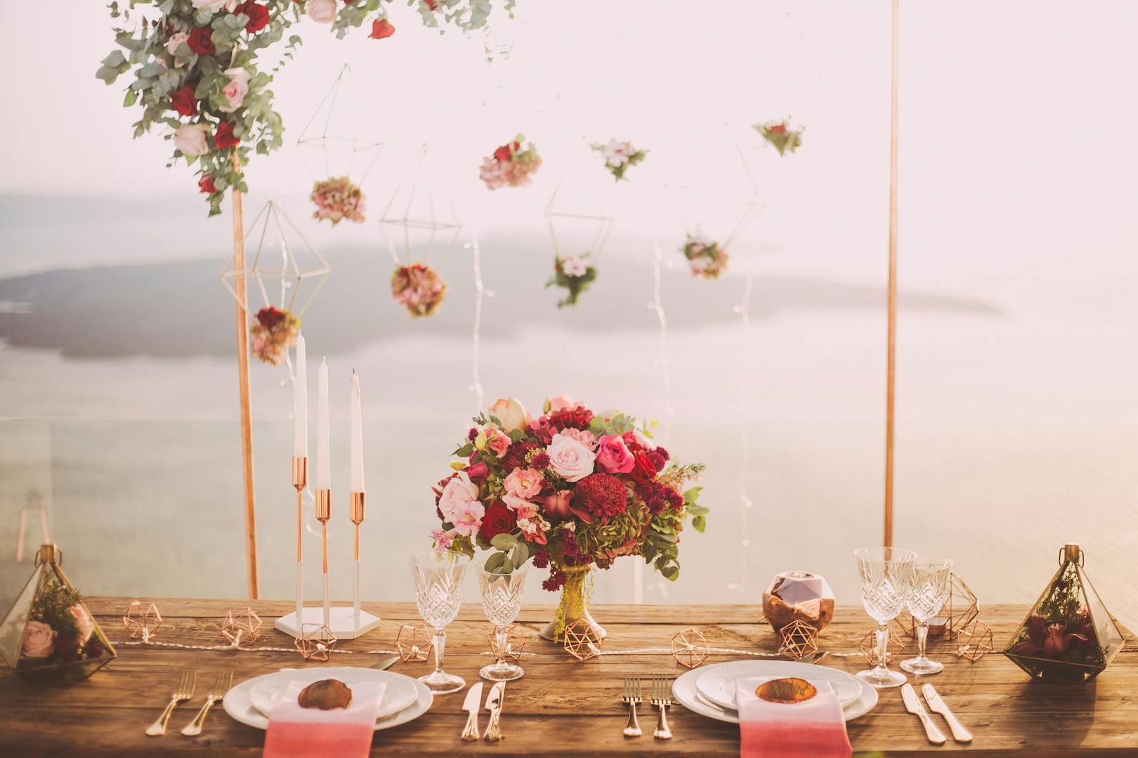 Elegant dukat bord för bröllop med blommor, ljus och utsikt över vatten.